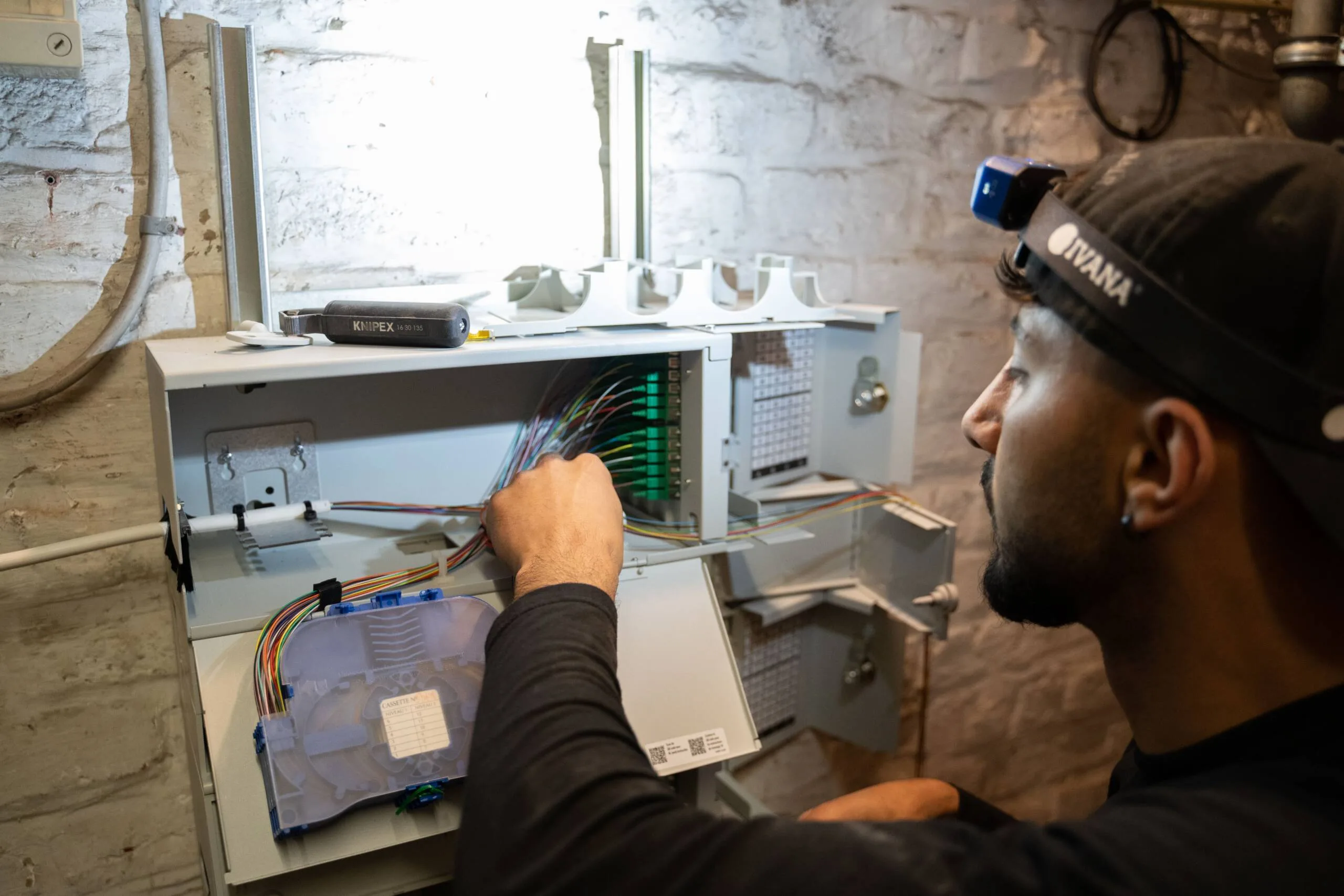 Technieker van A-NET last glasvezel in een gebouw