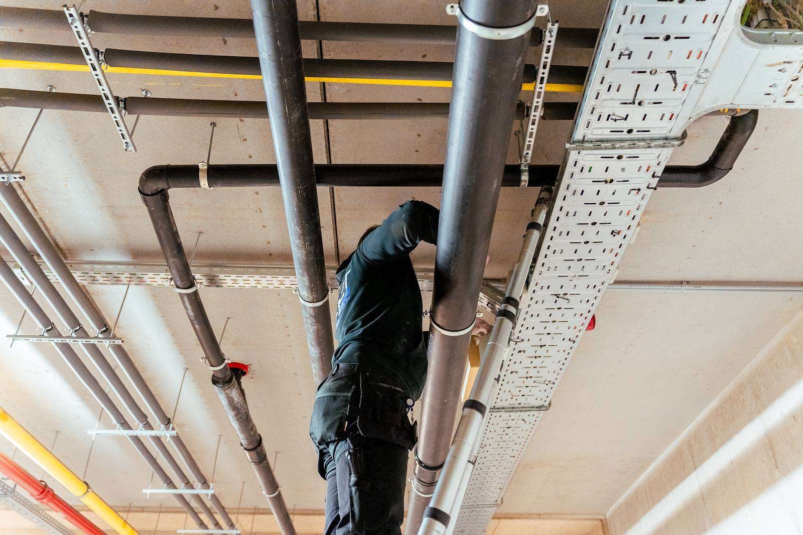 Technicus van A-NET aan de kabelgoten in een parkeergarage